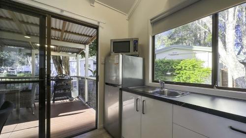a kitchen with a stainless steel refrigerator and a balcony at Ingenia Holidays Bonny Hills in Bonny Hills
