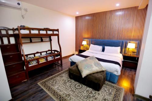a bedroom with a bed and two bunk beds at Sardar Villa NathiGalli in Bāzār