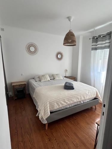 a bedroom with a large bed with a wooden floor at Appartement spacieux in Jurançon