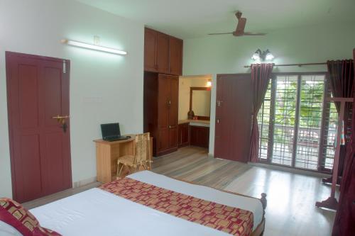 a bedroom with a bed and a desk in a room at Lake County Heritage Home in Cochin