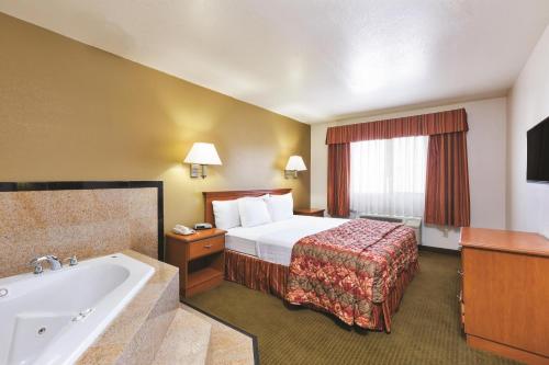 a hotel room with a bed and a bath tub at Baymont by Wyndham Tehachapi in Tehachapi