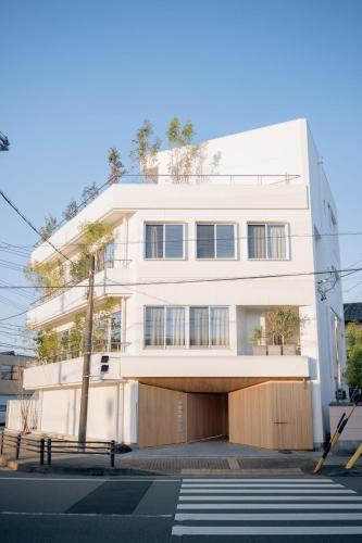 a white building on a street with a crosswalk at Experience Ise Miyamachi Hotel in Ise