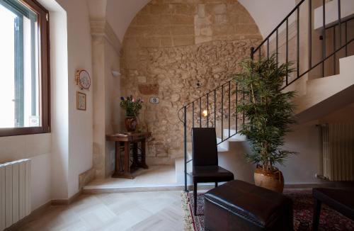 a hallway with a staircase with a chair and a plant at Corte Delle Moline in San Cesario di Lecce