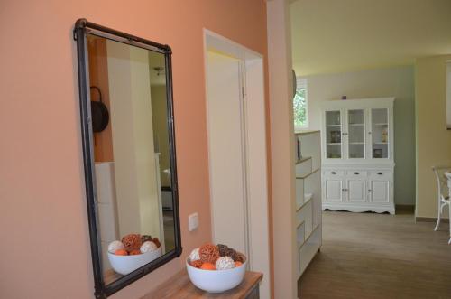 een spiegel in een kamer met twee kommen ballen bij Ferienwohnung an der Elbe in Dresden