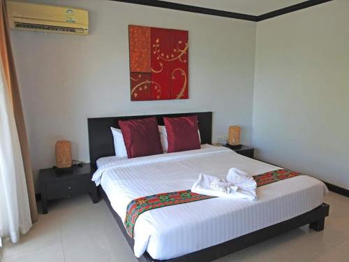 a bedroom with a large bed with red pillows at Napalai Resort Hua Hin in Hua Hin