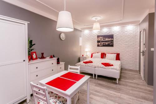 a bedroom with a bed and a table with a red blanket at Best Studio in Wrocław