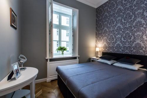 1 dormitorio con cama, mesa y ventana en Poznańska Metro Centrum Apartment, en Varsovia