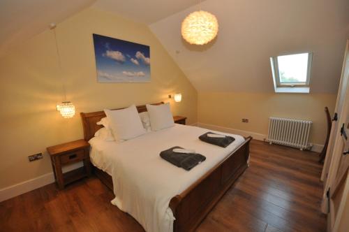 a bedroom with a large bed with two towels on it at Montgomery Barn in Bideford