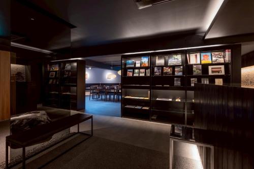 a room with a display case with a couch and tables at Experience Ise Miyamachi Hotel in Ise