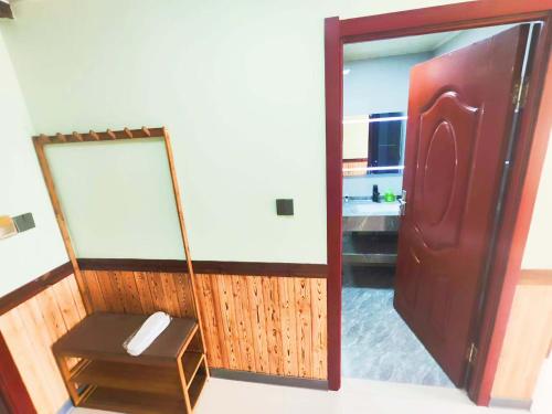 a door to a room with a mirror and a table at Snow Valley Ma Hua Inn in Wuchang