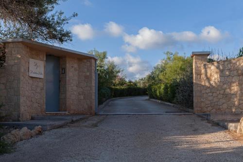 an empty road with a stone wall and a building at Dialiskari Villas in Marathopolis