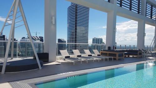 a pool on the roof of a building with chairs at Downtown Miami Deluxe Apartment in Miami