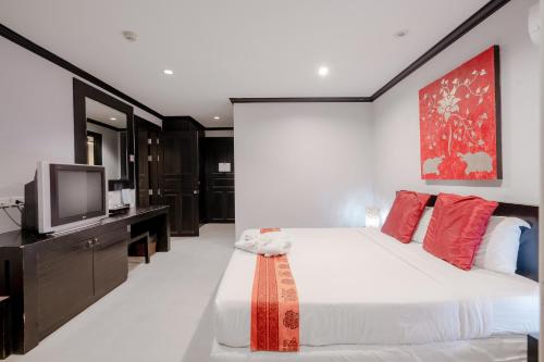 a bedroom with a large bed with a tv on it at Napalai Resort Hua Hin in Hua Hin