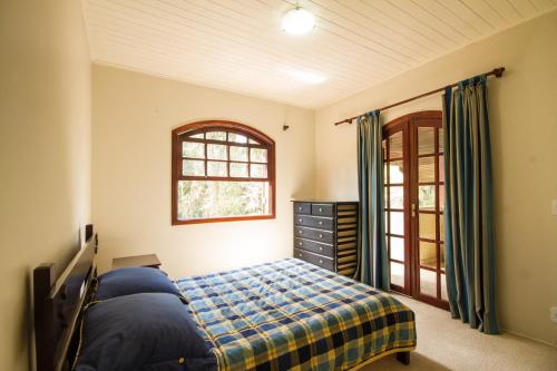 a bedroom with a bed and a window at Cobertura Morro do Elefante in Campos do Jordão