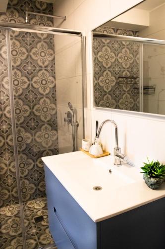a bathroom with a sink and a shower at הבית ליד הבוסתן דירה לזוג in Mikhmannim