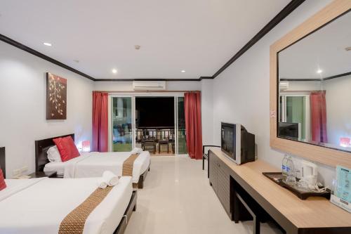 a hotel room with two beds and a television at Napalai Resort Hua Hin in Hua Hin
