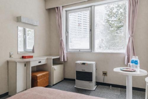 a room with a bed and a table and a window at 雪场缆车站旁 Hotel Justice-Ski IN Ski OUT-独立卫浴 in Seki