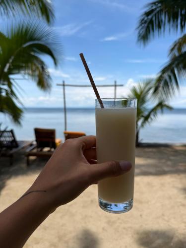 a hand holding a glass of milk with a straw at le Repaire des Pirates in Sainte Marie