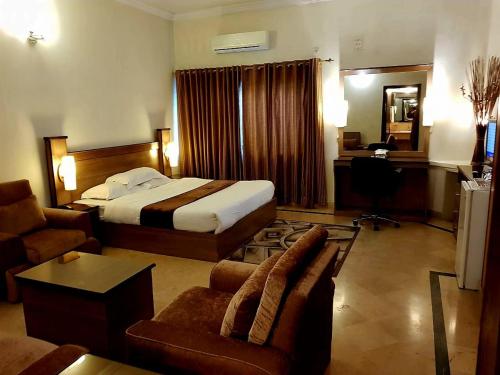 a hotel room with a bed and a desk at Peace House II in Islamabad