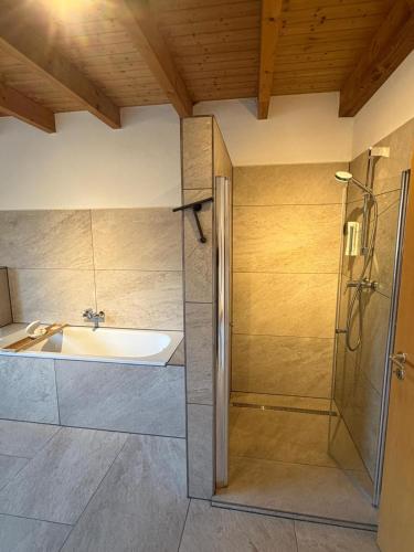 a bathroom with a tub and a sink and a shower at Aparthotel Casa Vasco - by Willms & Schömer eG in Euskirchen