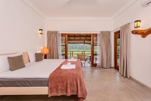 a bedroom with a large bed and a balcony at OMA Hikkaduwa in Hikkaduwa