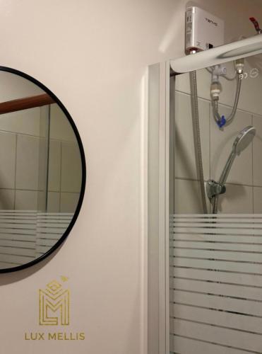 a bathroom with a shower with a mirror on the wall at Sophisticated 1BR Unit w Panoramic Horizon View in Cebu City