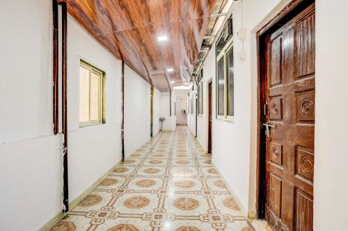 an empty corridor with a tile floor and a wooden door at Hotel O Vira Palace in Mumbai