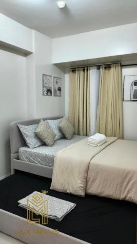 a bedroom with two beds and a couch at Sophisticated 1BR Unit w Panoramic Horizon View in Cebu City