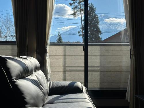 a couch sitting in front of a large window at 72 Mt View - B棟 - in Fujikawaguchiko