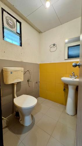 a bathroom with a toilet and a sink at River Edge Resort & Café in Kumta