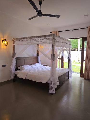 a bedroom with a bed with a canopy at The Arch View in Habaraduwa Central