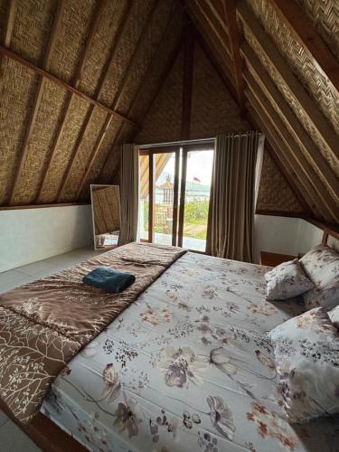 a large bed in a room with a window at Surya Camp Buahan in Kubupenlokan