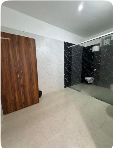 a bathroom with a wooden cabinet and a glass door at Hill Touch Villa in Thūr