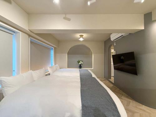 a large white bed in a room with a window at Clio Matoba by b hotel - Fully Equipped Studio 10min to Hiroshima Station in Ōsukachō