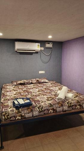 a bed with a comforter and a air conditioner at Nature Retreat Stay in Pondicherry