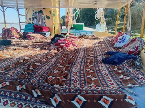 a bed on a boat with a rug on it at Aswan all-inclusive private felucca in Aswan