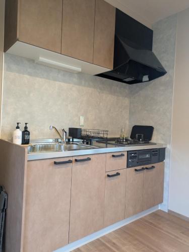 a kitchen with a sink and a stove at 南阿蘇サウナ5gaku G5 in Minami Aso