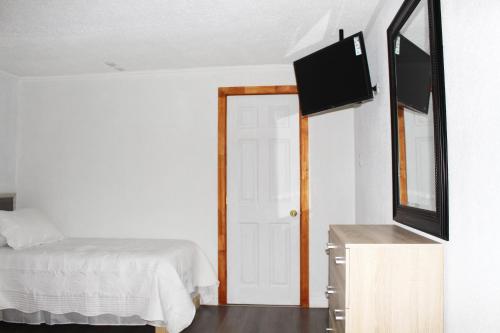 a bedroom with a bed and a flat screen tv at Residencial Victoria Said in Linares