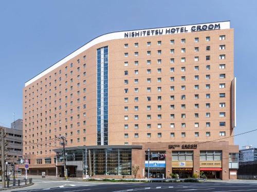 a hotel building with a sign on top of it at Nishitetsu Hotel Croom Hakata in Fukuoka