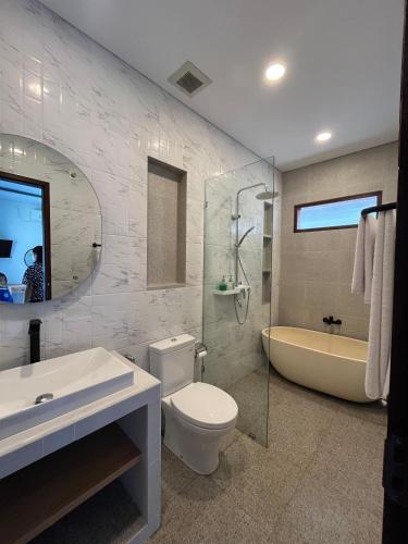 a bathroom with a toilet and a sink and a tub at Ngijeng Villa in Saba