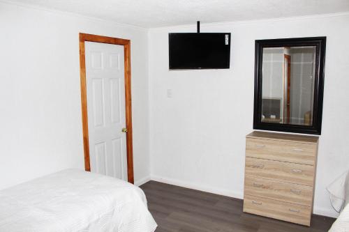 a bedroom with a bed and a dresser with a mirror at Residencial Victoria Said in Linares