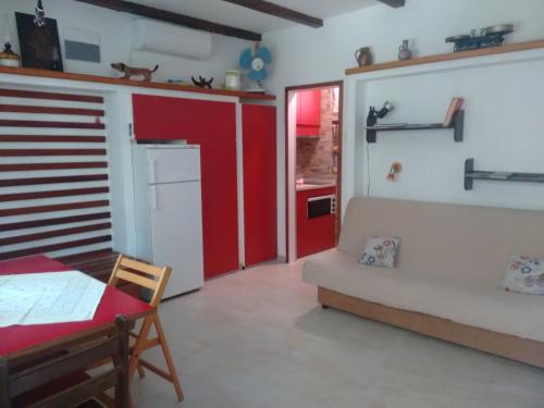 a kitchen with red cabinets and a table in a room at Vintage Summer House in Budva