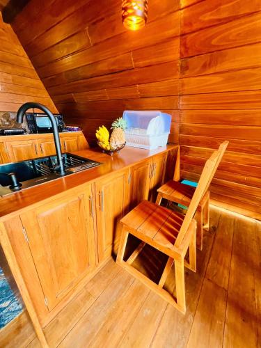 a kitchen with a sink and a chair in a cabin at Eco Cabana Bellwood Kandy in Kandy