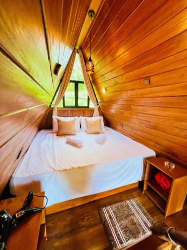 a bedroom with a bed in a wooden cabin at Eco Cabana Bellwood Kandy in Kandy