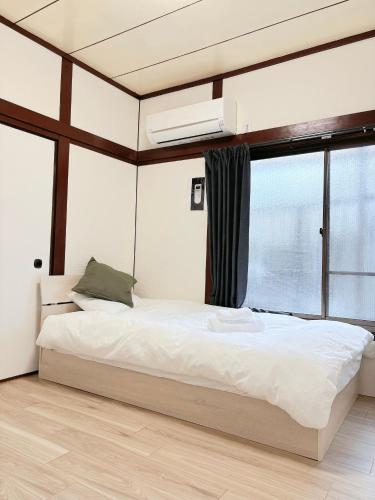 a bedroom with a large bed and a window at はつはな in Osaka