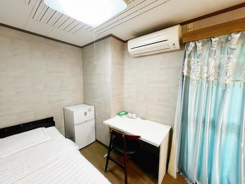 a small room with a desk and a bed and a table at 烟雨轩 303 in Tokyo