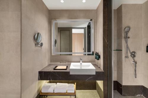 a bathroom with a sink and a shower at Ramada by Wyndham Sonipat Murthal in Sonīpat