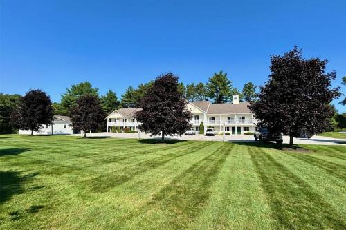 a large house with a large yard with green grass at Golden Gables Inn Dazzler Select by Wyndham in North Conway