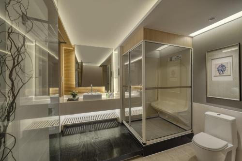 a bathroom with a glass shower and a toilet at Dongguan Royal Garden Hotel in Dongguan