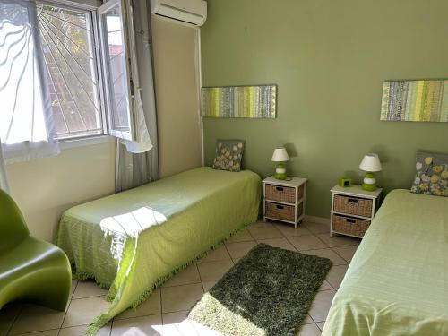 a bedroom with two twin beds and a window at A La Maison De Nani in Saint-Paul